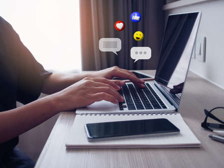 Asian woman using laptop chatting live online on digital social media with chatting box and emoji...