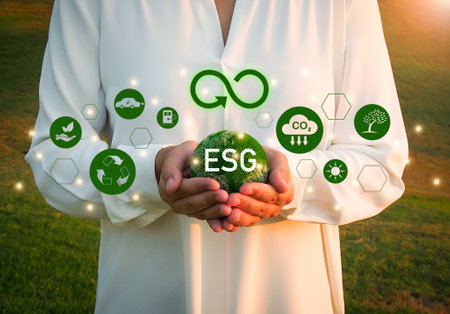 Green earth in human hand on a green field background, the concept of Environmental, Social and Governance, ESG sustainability.の写真素材