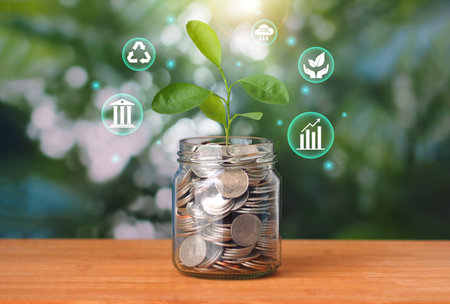 Sustainable investment concept, sustainability fund. Coins in a glass jar with a plant growing on top Surrounded by financial and sustainability icons.の写真素材