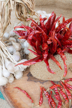 Organic garlic and red hot chili pepper on the old wood table closeup shotの写真素材