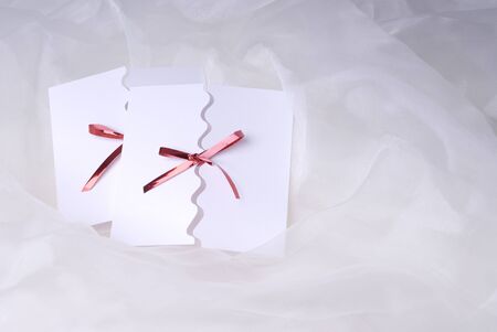 two white handmade invitation on white silk backgroundの写真素材