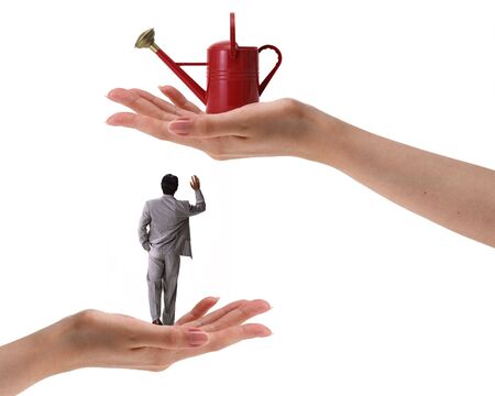 hands holding red watering can and manの写真素材
