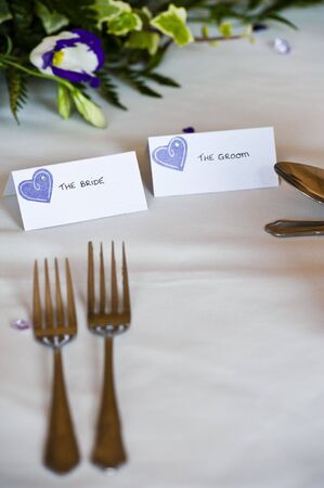 table setting at wedding breakfast with bride and groom tagsの写真素材