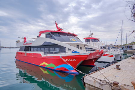 1st April 2019Beautiful port of Alicante, Spain at Mediterranean sea. Luxury yachts, ships, ferries and fishing boats sailing and standing in rows in harbor. Rich people traveling around the world.のeditorial素材