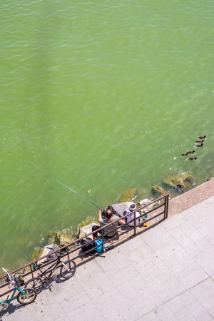 SEVILLE, SPAIN - JANUARY 21, 2018: people fishing at the riverbank in Seville, Andalusia, Spain.のeditorial素材