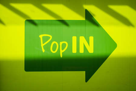 UNITED KINGDOM, LANCASTER - 9TH APRIL 2020 Arrow pop in shop sign in green and yellow with shadowsのeditorial素材