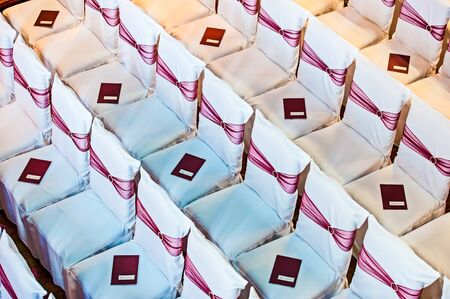 white covered wedding chair with maroon sashes and silver broocheの写真素材