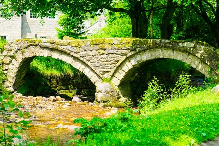 Thirteenth century packhorse bridge and the village of Wycoller.の写真素材