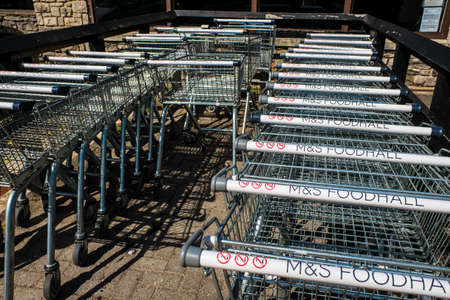 Kendal UK 28 May 2020 Row of M and S Foodhall trollies outside shop ready for shoppers to use.のeditorial素材