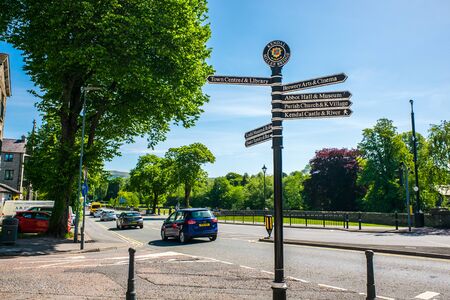 Town signpost showing directions to various places in the center of historical town Kendal. Kendal is considered as the southern gateway to the Lake District, UKの写真素材