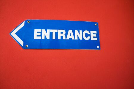 Entrance Sign mounted on a bright red wall UKの写真素材