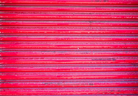 red roller shutter on the door of closed retail premises