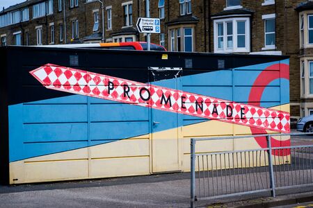 sign pointing to Morecambe promenade painted on a building in red and whiteの写真素材