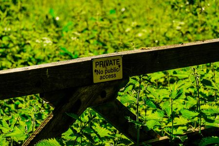 Private farm land fenced off by a large gate, close up of the private sign showing no access to the rural pathwayの写真素材