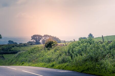 curved road in middle of rural Engalnd with dry stone wallsの写真素材