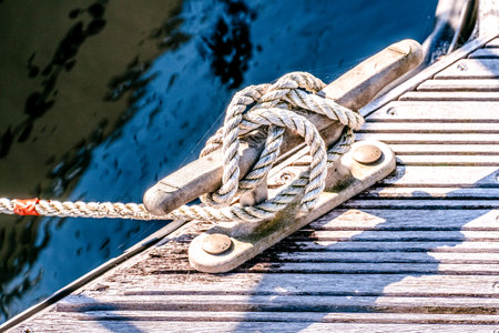 close up of yacht mooring rope tied around cleat in harbourの写真素材
