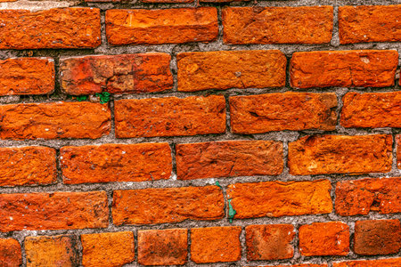 Old brick wall of red color, damaged masonry as abstract background composition. textured surface of stucco textureの写真素材