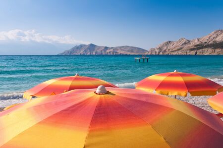 Orange Sunshades on beach at baska - Krk - Croatiaの写真素材