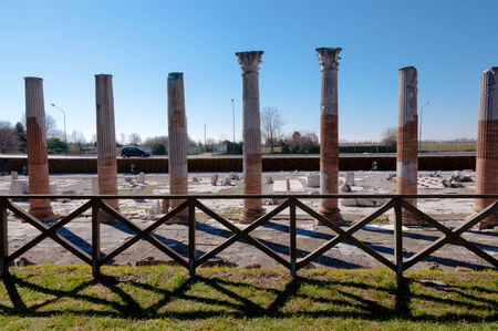 Roman columns and fence on Archeological area of Aquileia in Italyの写真素材