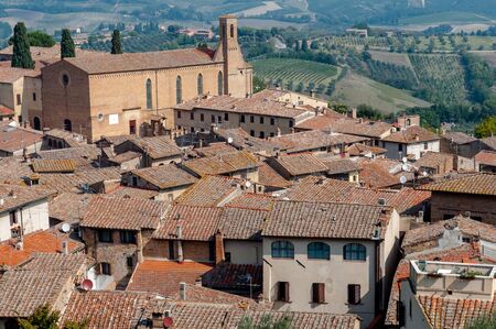 Sant Agostino church and houses rooftops at San Gimignano - Italyの写真素材