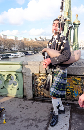 LONDON, FEBRUARY 04: Piper on the bridge over the River Thames. UK 2017.