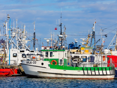 WLADYSLAWOWO, AUGUST 06: A small fishing boat moored next to other boats in the harbor on a sunny...