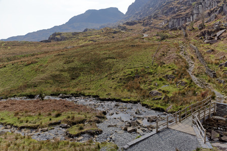 Wooden bridge on the Cwmorthin Waterfall trail in the mountains of Snowdonia National Park, Wales.の写真素材