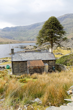 A stone house by the lake in the mountains of Snowdonia National Park, Wales.の写真素材