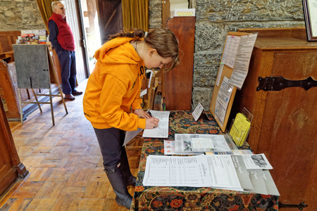 The girl writes to the memorial book inside the Saint Twrog's Church in Maentwrog, Snowdonia, Wales, April 11, UK 2018のeditorial素材