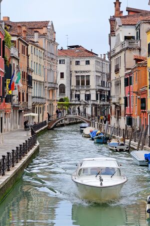Motorboats sailing along the canal between historic buildings in Venice, May 4, Italy 2018のeditorial素材