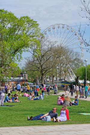 People rest on the grass overlooking the Ferris wheel in Stratford-upon-Avon, April 24, UK 2021のeditorial素材