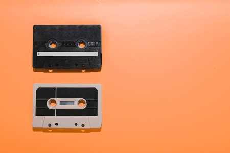 Two audio cassette tapes isolated on orange background. Copy spaceの写真素材