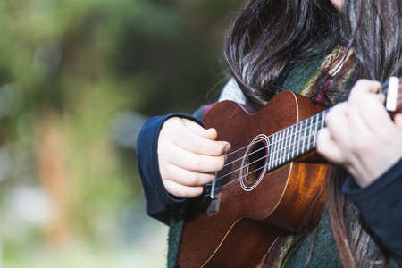Young woman playing ukelele. Natural space. Copy-space