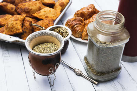Mate, empanadas and croissants over a white wooden table. Family dinnerの写真素材