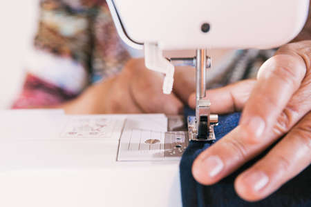 unrecognizable woman using a sewing machine to manufacture clothing. Employment issuesの写真素材