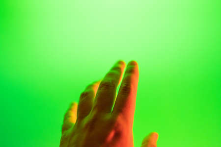 young mans hand trying to touch a green screen. Virtual reality. VR.の写真素材