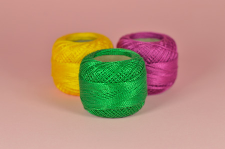 Composition of balls of yarn with pink background for your craft projects.