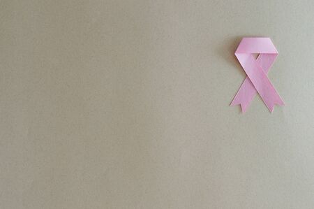 Breast cancer ribbon made from paper with beige background.の写真素材