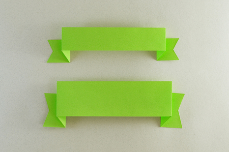 Two green slats of paper one thin and one thick with beige background.の写真素材