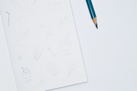 Square sketchbook with handmade drawings of frozen desserts, pencil line style on white background