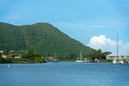 Gros Islet, St lucia - Sep 19, 2018: Bay with sailboats, building and mountain in trhe backのeditorial素材