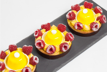 cakes with jelly and raspberry on a black plateの写真素材