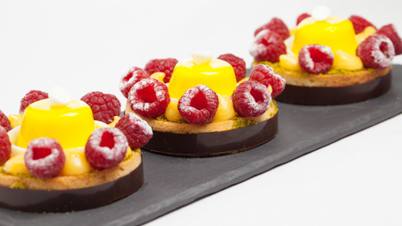 cakes with jelly and raspberry on a black plateの写真素材