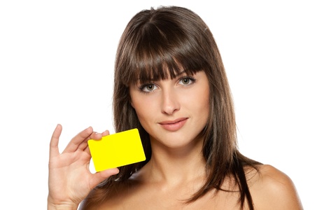 Close-up portrait of young female holding discount card isolated on white backgroundの写真素材