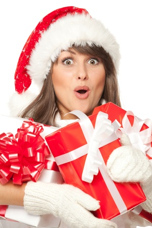 Closeup of a girl in Santa hat, surprised by having received a lot of Xmas presents, over white backgroundの写真素材