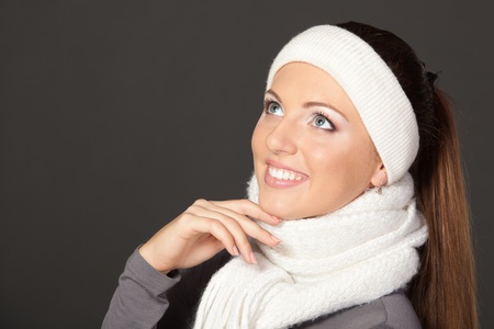 Side view of closeup of a girl in warm clothing looking upwards, over grey backgroundの写真素材