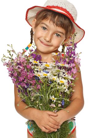 Five years old girl in summer hat holding a bunch of field flowers, over white backgroundの写真素材
