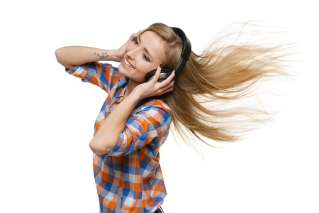 Happy young woman enjoying music against white backgroundの写真素材