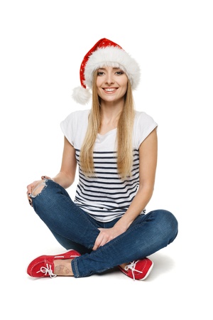 Woman in Santa s hat sitting on floor in lotus pose, isolated on white backgroundの写真素材