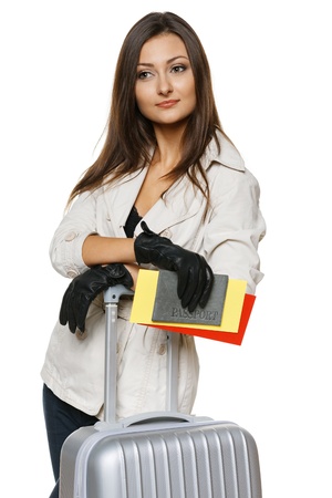 Young female in autumn clothing standing with travel bag, holding passport and tickets,isolated on withe backgroundの写真素材